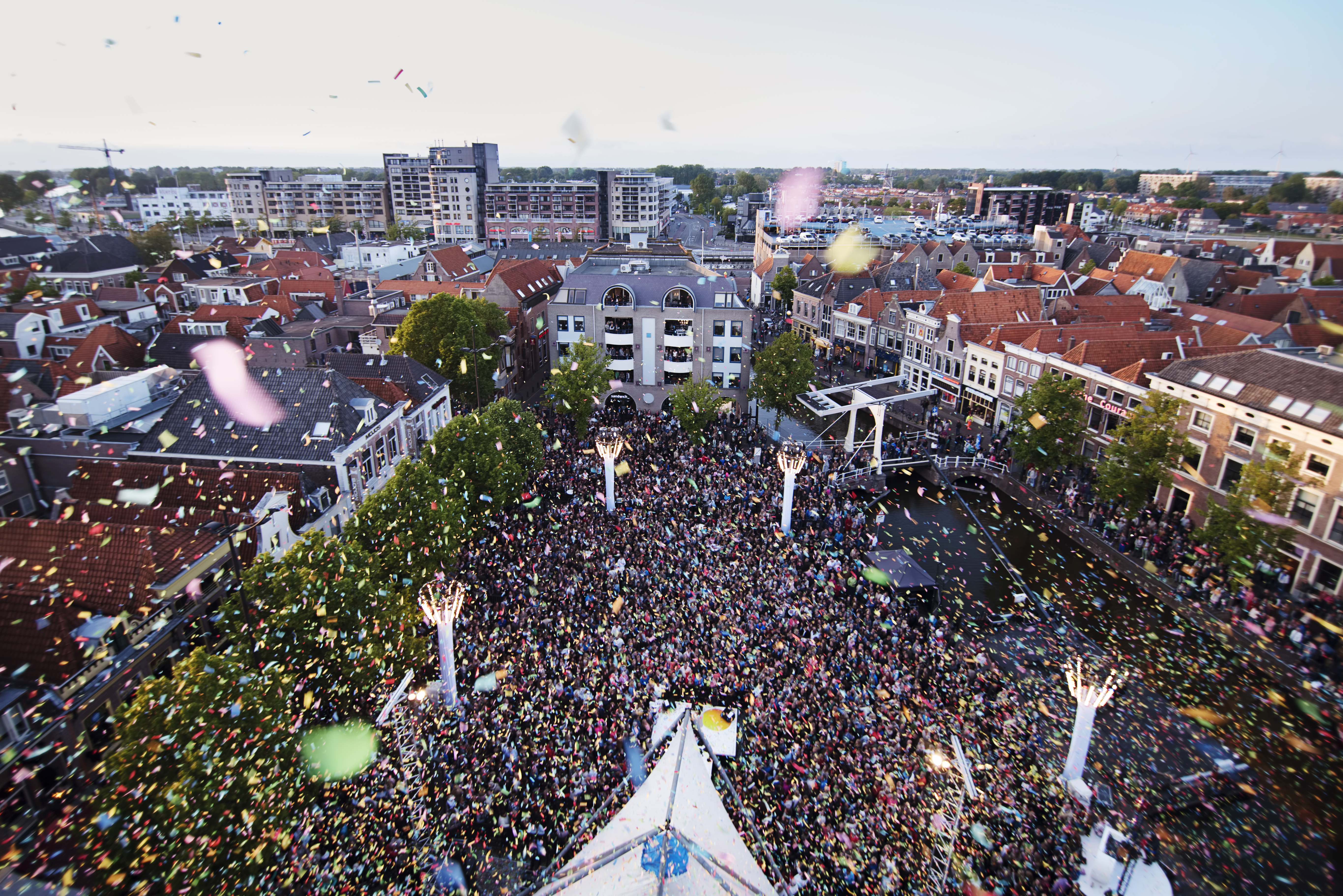 Waagplein van bovenaf met veel publiek en confetti
